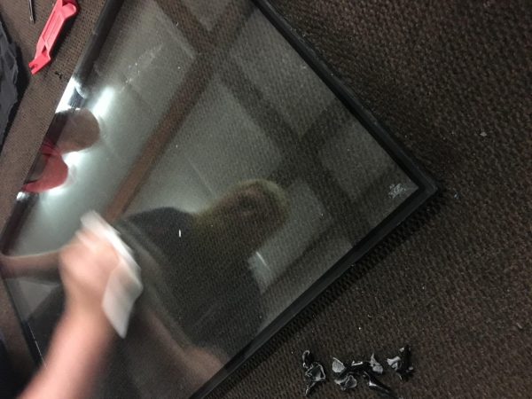 cleaning glass window to put construction tape on it